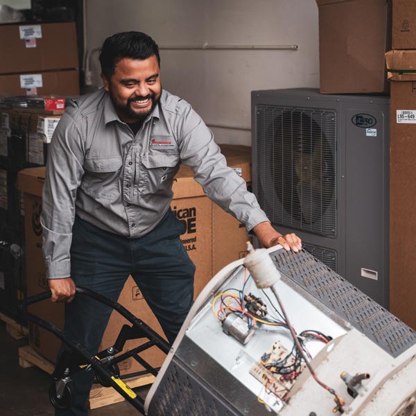 technician moving old HVAC unit