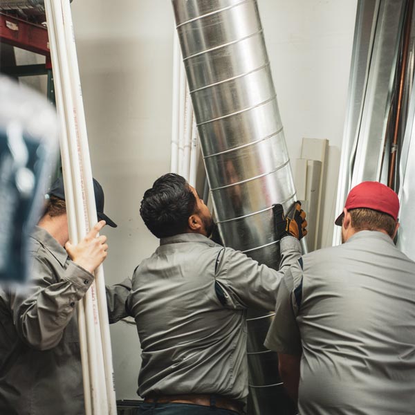 three technicians grabbing ductwork