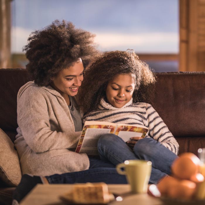 mother and daughter reading on couch